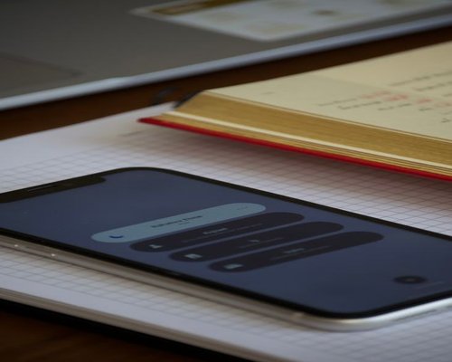 Notebook, phone and water on a desk